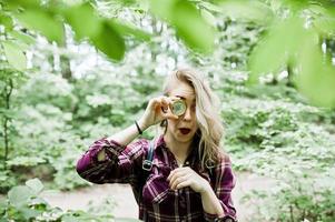 portret van een aantrekkelijk blond meisje poseren met een kompas in een bos. foto