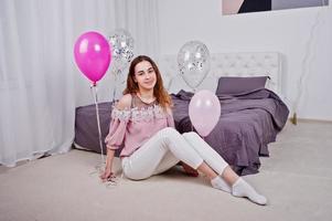 jong meisje met ballonnen op bed gesteld op studio kamer. foto