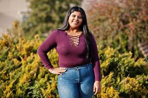 mooie latino xxl model meisje uit ecuador slijtage op violet blouse gesteld op straat. foto