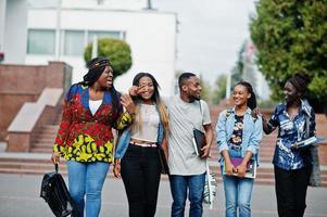 groep van vijf afrikaanse studenten die samen tijd doorbrengen op de campus op de universiteitswerf. zwarte afro-vrienden studeren. onderwijs thema. foto