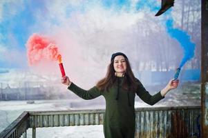 jong meisje met blauw en rood gekleurde rookbom in handen. foto