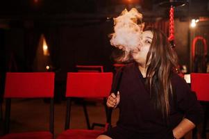 Aziatisch meisje rook waterpijp in de loungebar. foto