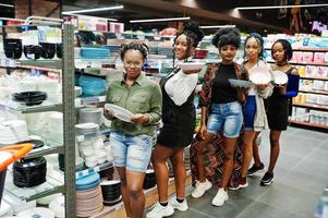 groep afrikaanse dames kijken kleurenplaten op de schappen van de supermarkt. foto