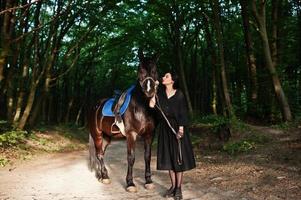 mystieke meisjeskleding in zwart met paard in hout. foto