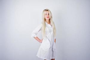 aantrekkelijke blonde vrouwelijke arts of verpleegkundige in laboratoriumjas geïsoleerd op een witte achtergrond. foto