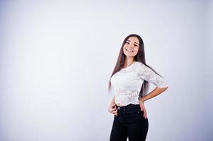 portret van een elegante jonge vrouw in witte top en zwarte broek in de studio. foto