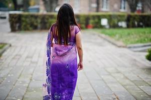 indiase hindoe meisje op traditionele violet saree poseerde op herfst straat. foto