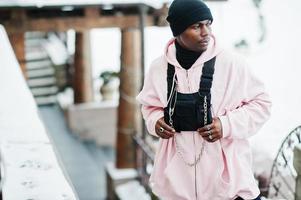 stijlvolle stedelijke stijl Afro-Amerikaanse man in roze hoodie gesteld op winterdag. foto