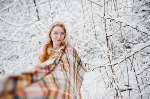 portret van blond meisje in glazen, rode bontjas en sjaal op winterdag. foto