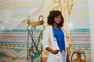 Afro-Amerikaanse arts student vrouw bij laboratoriumjas met stethoscoop binnen medische universiteit. foto
