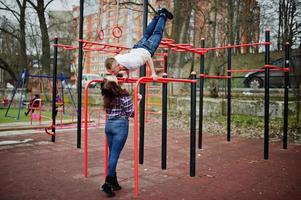 stijlvolle paar slijtage op geruit hemd verliefd samen zoenen op bars training. foto