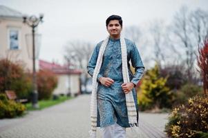 indiase man draagt traditionele kleding met witte sjaal buiten geposeerd. foto