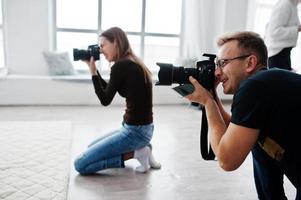 het team van twee fotografen die op studio schieten. professionele fotograaf op het werk. foto