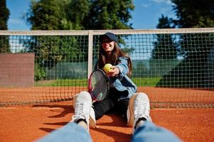 jonge sportieve meisjesspeler met tennisracket op tennisbaan. foto