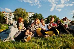 jonge multi-etnische groep mensen kijken naar film op poef in openluchtbioscoop. foto