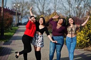 groep van vier gelukkige en mooie latino-meisjes uit ecuador poseerden op straat. foto