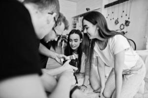 het team van fotografen die foto's op het scherm van de camera tonen voor tweelingmodellen, meisjes in de studio. professionele fotograaf op het werk. foto