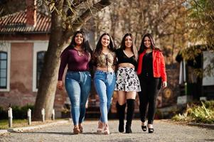 groep van vier gelukkige en mooie latino-meisjes uit ecuador poseerden op straat. foto