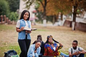 groep van vijf afrikaanse studenten die samen tijd doorbrengen op de campus op de universiteitswerf. zwarte afro-vrienden studeren. onderwijs thema. foto