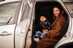 jonge moeder en kind in auto. veiligheid rijden concept. foto