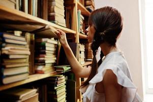 meisje met staartjes in witte blouse bij oude bibliotheek. foto