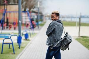 jonge duizendjarige Afro-Amerikaanse meisje in de stad. gelukkige zwarte vrouw met draadloze oortelefoons. generatie z-concept. foto