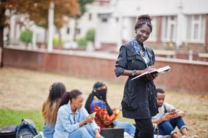 groep van vijf afrikaanse studenten die samen tijd doorbrengen op de campus op de universiteitswerf. zwarte afro-vrienden studeren. onderwijs thema. foto