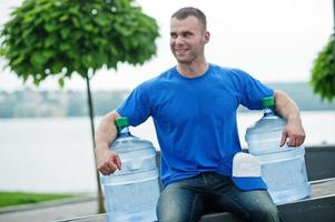 bezorger zit met flessen water buiten. foto