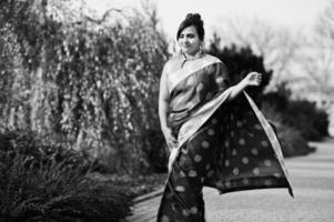 elegante brunette Zuid-Aziatische Indiase meisje in saree wandelen buiten. foto
