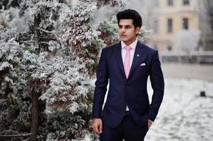 elegante Indiase macho man model op pak en roze stropdas gesteld op winterdag. foto