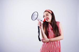 portret van een jonge mooie vrouw in rode jurk praten in megafoon. foto