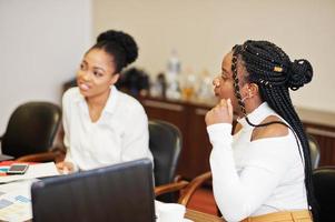 Afro-Amerikaanse vrouwelijke collega's, bemanning van divercity vrouwelijke partners in functie zitten aan tafel. foto