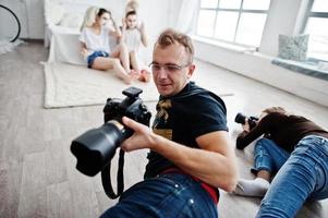 het team van twee fotografen die foto's maken van studio-tweelingmeisjes terwijl ze hun eigen maskercrème maken. professionele fotograaf op het werk. foto