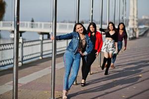 groep van vier gelukkige en mooie latino-meisjes uit ecuador poseerden op straat. foto