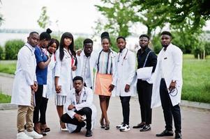 groep afrikaanse medische studenten poseerde buiten in witte laboratoriumjassen. foto