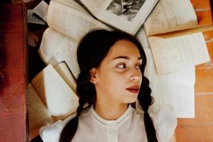 meisje met staartjes in witte blouse bij oude bibliotheek. foto