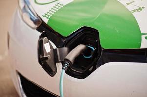 voeding aangesloten op een elektrische auto die wordt opgeladen foto