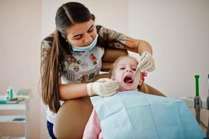 babymeisje bij tandartsstoel. kinderen tandheelkundige. foto