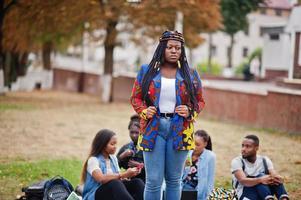 groep van vijf afrikaanse studenten die samen tijd doorbrengen op de campus op de universiteitswerf. zwarte afro-vrienden studeren. onderwijs thema. foto