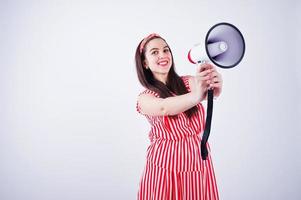 portret van een jonge mooie vrouw in rode jurk praten in megafoon. foto