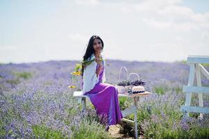 mooi indiaans meisje draagt saree india traditionele kleding in paars lavendelveld. foto