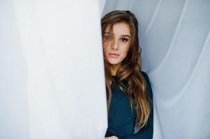 knappe brunette meisje slijtage op groen, poseren op gordijnen. studiomodel portret. foto