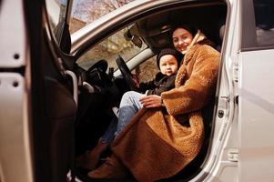 jonge moeder en kind in auto. veiligheid rijden concept. foto