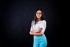 portret van een jonge gelukkige vrouw in witte top en blauwe broek met een kopje koffie in haar hand. foto