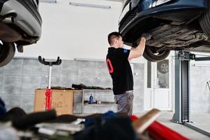 auto reparatie en onderhoud thema. monteur in uniform werken in autoservice. foto