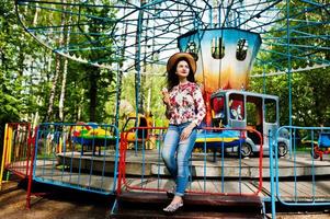 portret van brunette meisje in roze bril en hoed met ijs in pretpark. foto