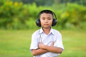 schoolkinderen luisteren graag naar muziek met een koptelefoon op het gazon, redido-koptelefoons. foto