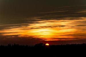 oranje zonsondergang aan de horizon foto