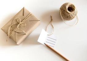 geschenkdoos verpakt in kraftpapier en rustieke hennep als natuurlijke rustieke stijl foto