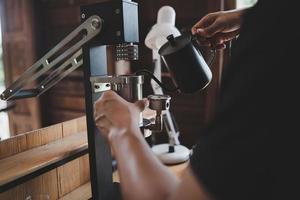 barista café koffie maken met handmatige hendel espressomachine voorbereiding serviceconcept in restaurant. close-up handbarista die verse koffie maakt met een koffiezetapparaat in het café. verse koffie zetten. foto